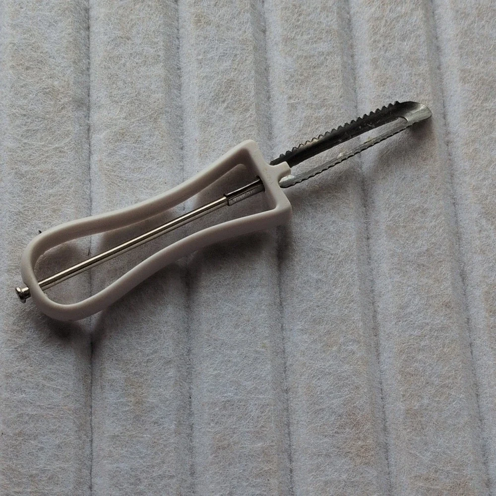 Manual Serrated Vegetable Peeler with‎ White Plastic Handle and Metal Blade